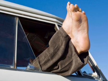 mužské nohy trčia z okna auta