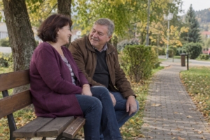 Dvojica na lavičke pri mestskej promenáde so zeleňou, ilustračná AI fotografia