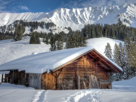 zasnežená chatka v Alpách