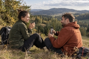 Dvojica odpočívajúca na výlete v podhorskej krajine, ilustračná AI fotografia