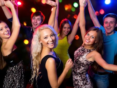 ľudia tancujú na párty s farebnými svetielkami