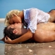 dvojica leží na brehu mora a bozkáva sa