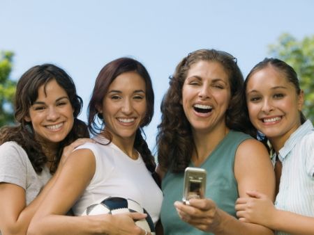 štyri mladé ženy sa fotia mobilom