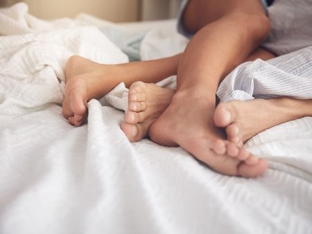 prepletené nohy dvojice v posteli