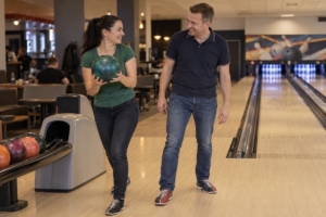 Dospelá dvojica pri spoločnej hre v bowlingovej hale, ilustračná AI fotografia