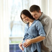 muž drží tehotnej žene brucho odzadu