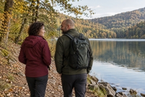 Dvojica na prechádzke pri jazere v mierne zvlnenej krajine, ilustračná AI fotografia