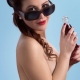 žena z boku hore bez s fľaškou coly v ruke a slnečných okuliaroch