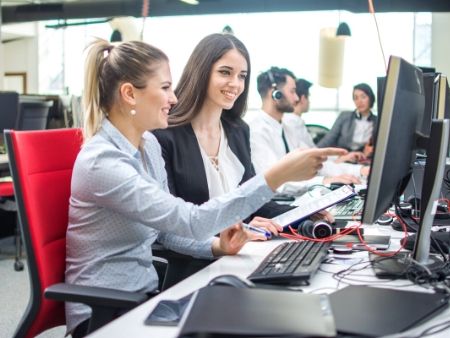 dve ženy sedia v kancelárii pri počítačoch