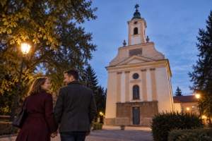 Dvojica pri kostole svätého Michala archanjela v Zlatých Moravciach za súmraku, ilustračná AI fotografia