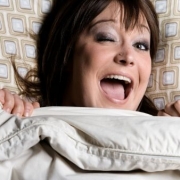 žmurkajúca zrelá žena v posteli